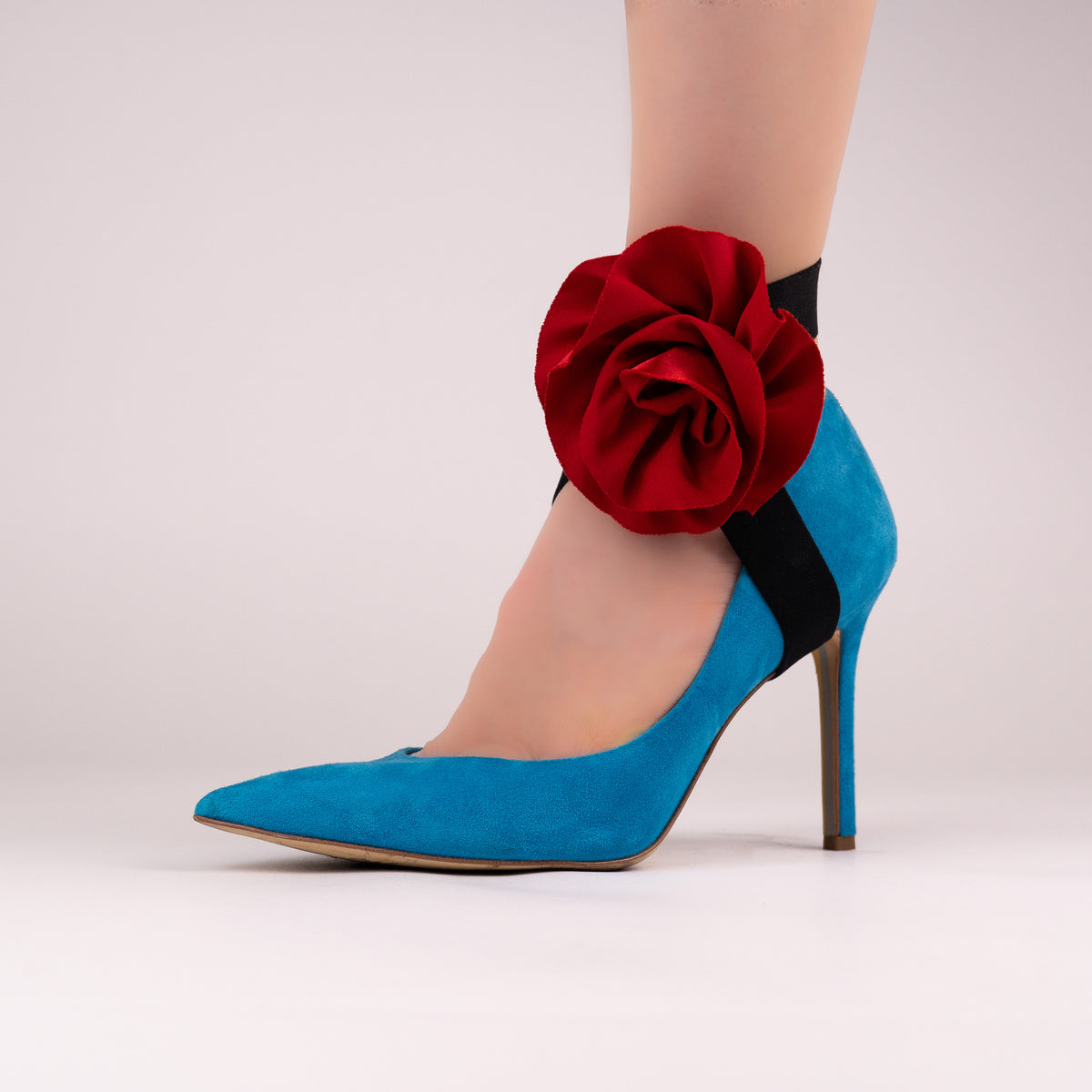 Red rose LYNKS straps styled on a bright blue pointed-toe pump
