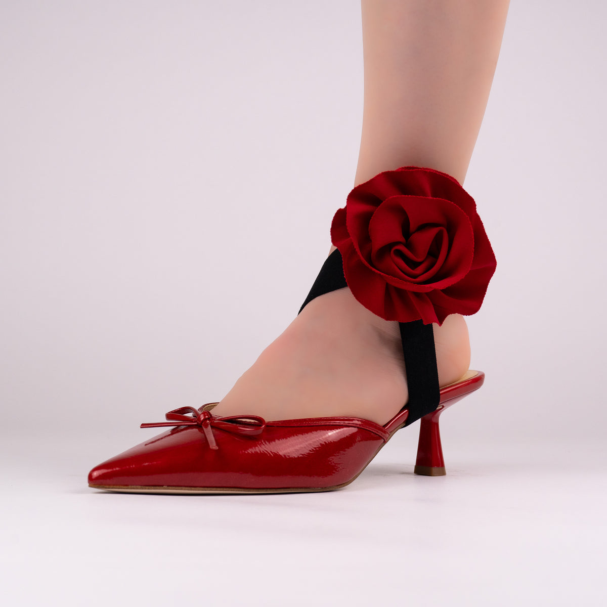 Red rose LYNKS straps styled on a red patent pointed-toe heel