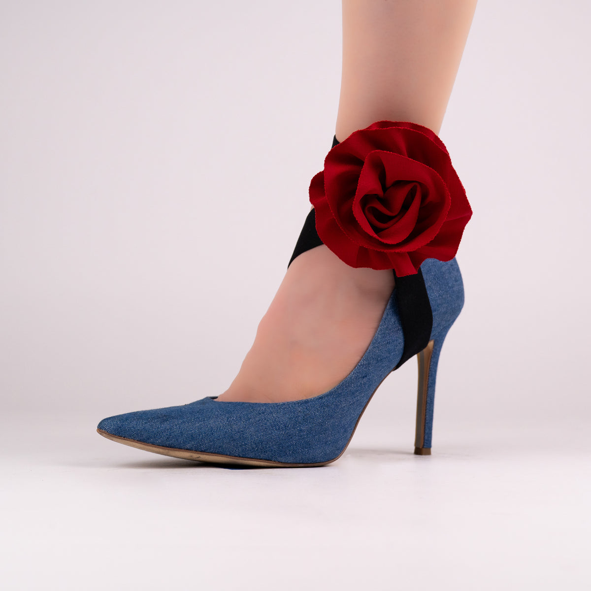 Red rose LYNKS straps styled on a blue denim pointed-toe pump