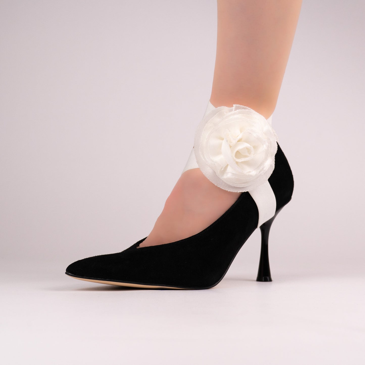 White rose LYNKS shoe straps styled on a black pointed-toe pump
