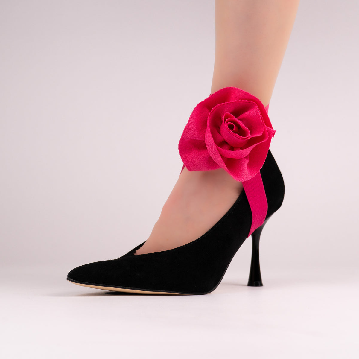 Pink rose LYNKS straps styled on a black pointed-toe pump