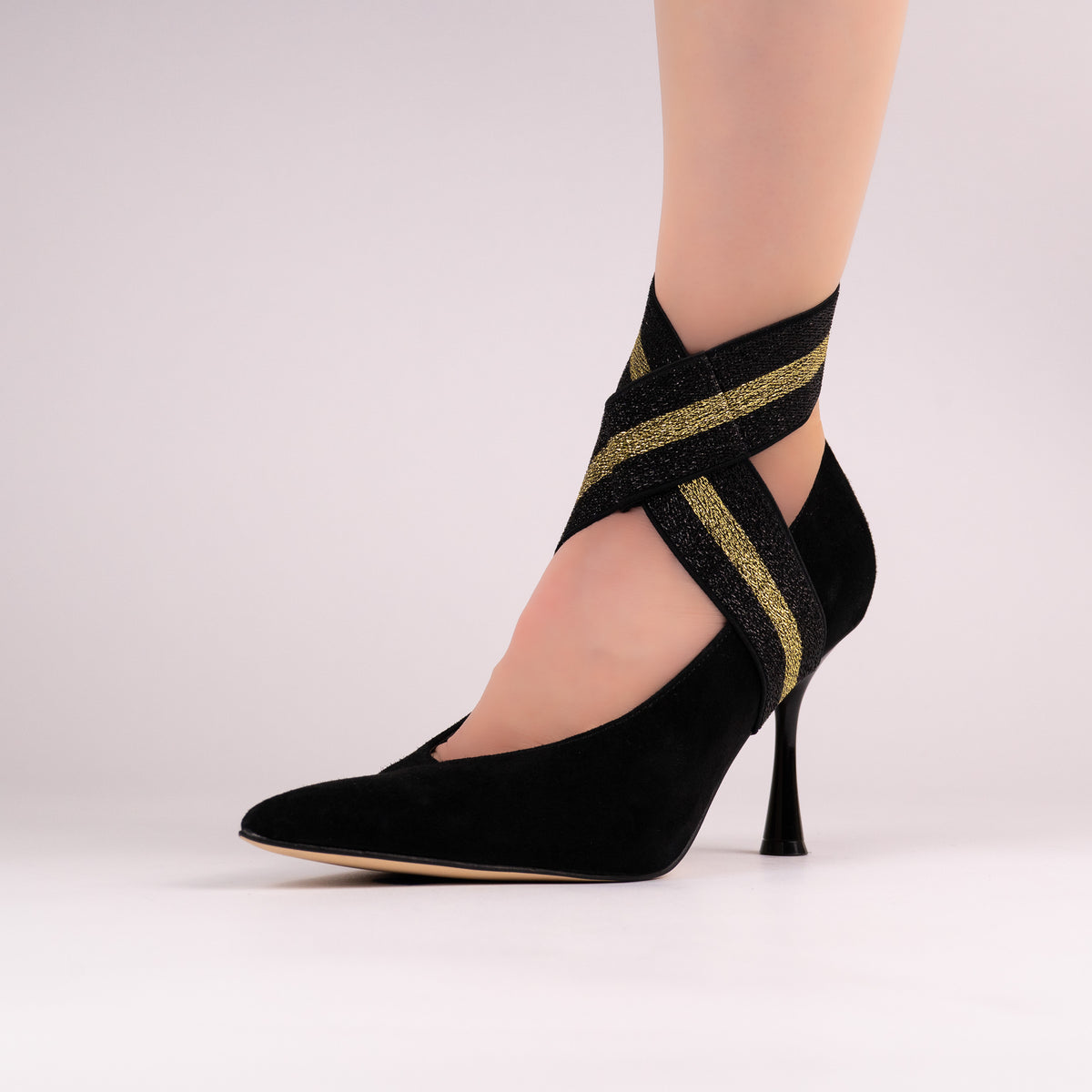 Black-and-gold stripe LYNKS straps styled on a black pointed-toe pump
